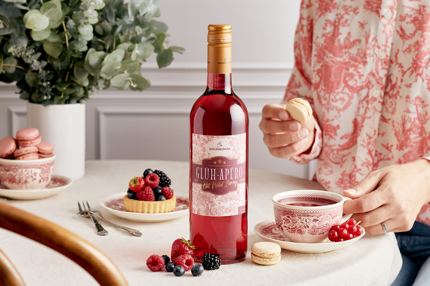 Flasche Glüh-Apero steht auf Tisch neben Beeren, Beveragefotografie